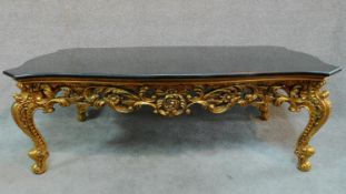 A gilt Rococo style coffee table with shaped marble top. H.47 W.139 D.79cm