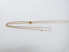 An antique yellow metal sliding rope fob chain, with a sliding bead carved in the form of a daisy