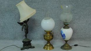 A spelter cherub table lamp, another Dutch style and a brass oil lamp. H.67cm