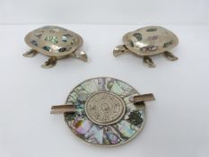 A pair of Mexican alpaca silver and abolone shell turtle boxes and a Incan sunwheel design alpaca