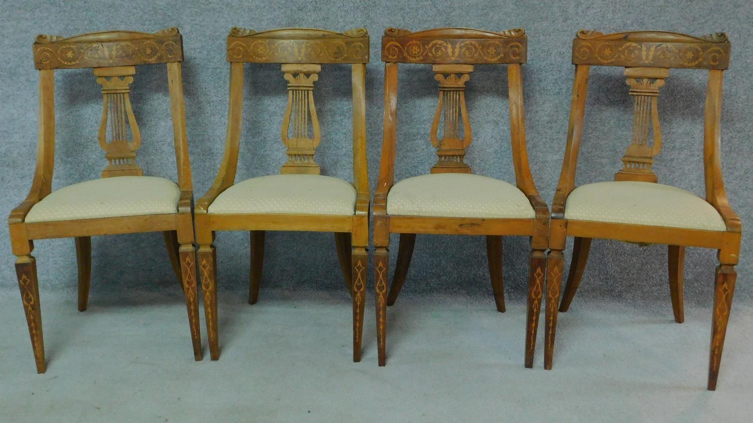 A set of four 19th century Continental walnut and satinwood inlaid chairs, lyre shaped backs on