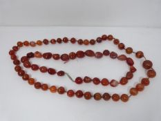 Two strings of antique Carnelian beads. One necklace comprised of 43 round knotted polished beads,