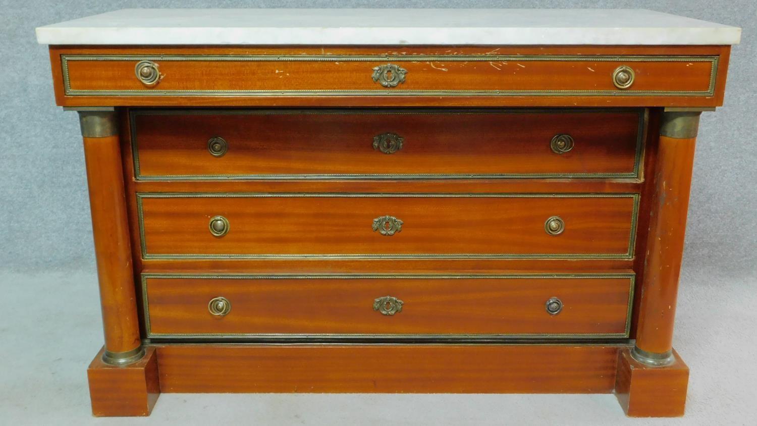 A Georgian style mahogany empire dresser with white marble top, decorative pillars to the sides