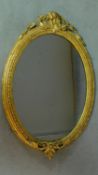 A 19th century oval wall mirror in decorative gilt frame. H.94cm