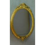 A 19th century oval wall mirror in decorative gilt frame. H.94cm