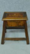 An Art Nouveau mahogany stool with hinged lidded compartment and copper inlaid urn motifs. H.40 W.42