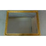 A rectangular gilt framed mirror with Rococo decoration. 136x106cm