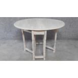 A small painted drop flap dining table with gateleg action. H.66 W.97 D.81cm