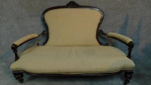 A Victorian carved mahogany framed open arm two seater sofa on turned tapering supports. H.104 W.