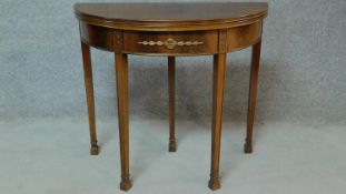 An Edwardian mahogany card table fitted frieze drawer with floral carvings to the centre and legs