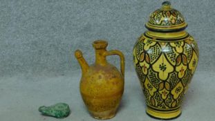 A vintage ceramic glazed lidded jar with bold geometric pattern, terracotta glazed oil flask and