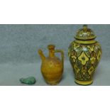 A vintage ceramic glazed lidded jar with bold geometric pattern, terracotta glazed oil flask and