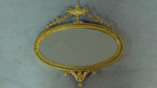 A 19th gilt framed Adam style wall mirror with oval plate and urn and swag decoration. 56x56cm