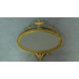 A 19th gilt framed Adam style wall mirror with oval plate and urn and swag decoration. 56x56cm