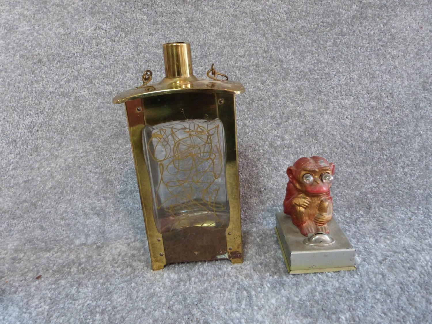 A vintage brass singing decanter and a painted monkey tin plate light. Sings Little Brown Jug. H