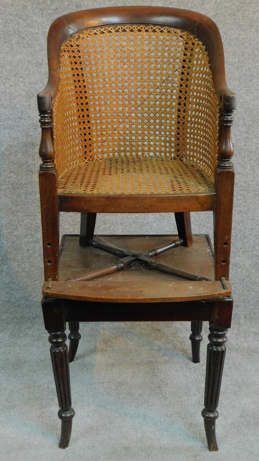 A Georgian mahogany child's bergere armchair on base with reeded swept supports. H.91cm