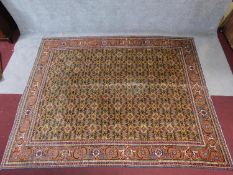 A large Persian Afshar style rug with allover floral motifs on a yellow ground within floral and