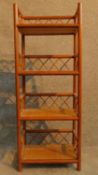 A 20th century teak and rattan whatnot. H.96 W.38 D.25cm