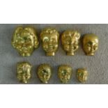 Eight antique brass boy and girl doll's head moulds, graduating in size. All with casting holes