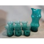 A set of six mid century blown glass turquoise tumblers with matching jug. Abstract design and