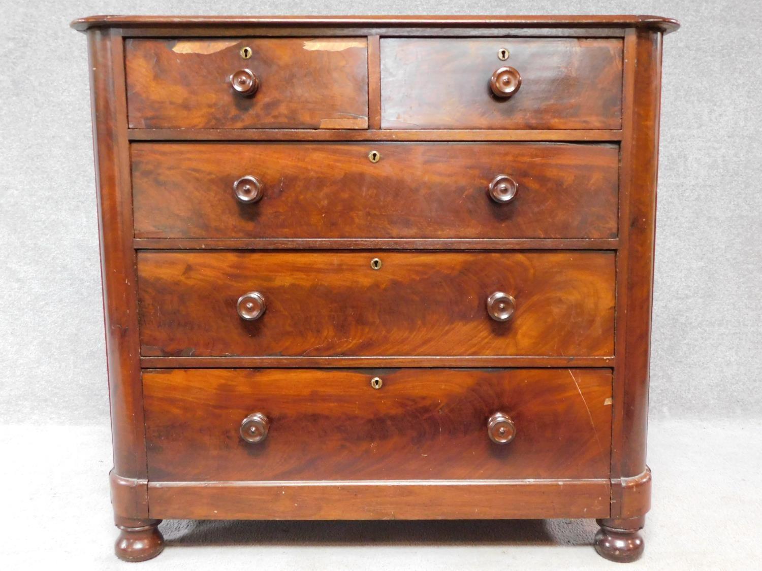 A Victorian mahogany chest of two short over three long drawers, raised on squat turned supports.