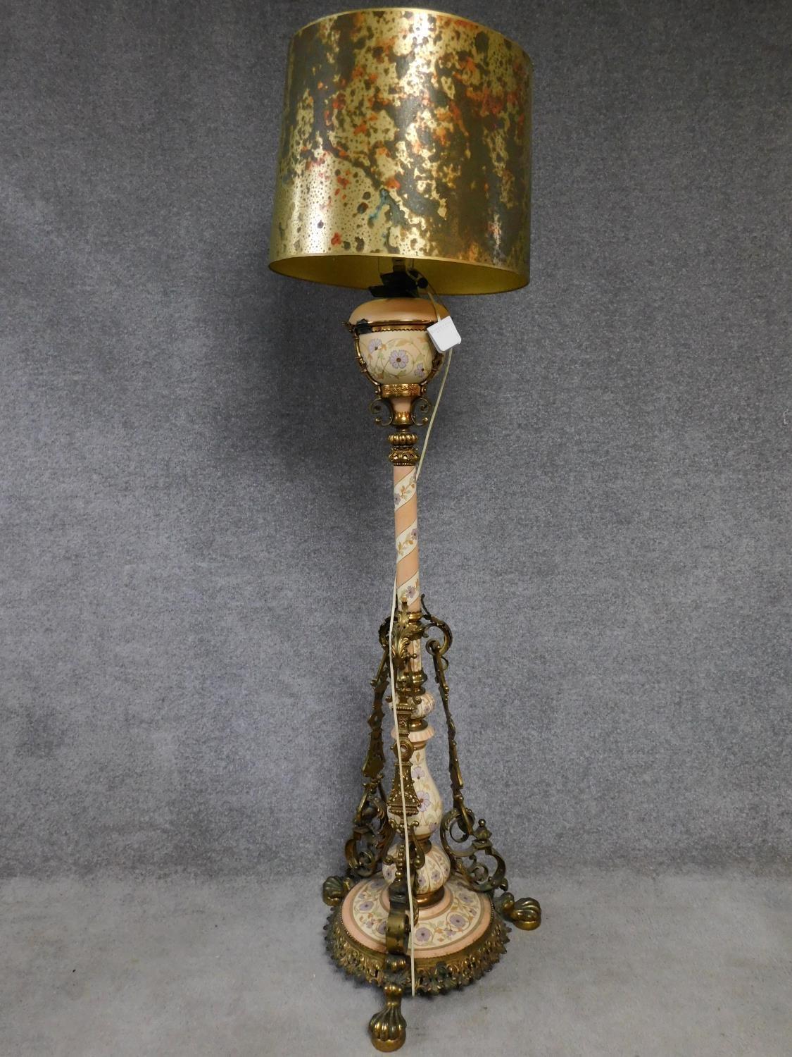 A ceramic and brass tall standard lamp with gilded and hand painted floral design. H.178cm