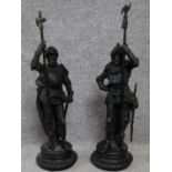 A pair of late 19th century cast spelter figures of armoured knights on round embossed detailed