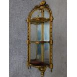 A 19th century carved giltwood mirror backed corner whatnot in the Rococo style. H.115cm