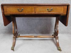 A Regency style mahogany drop flap sofa table with two dummy drawers opposing a pair of drawers.