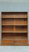 A Georgian mahogany open waterfall bookshelf fitted with two base drawers. H.133 W.107 D.30cm