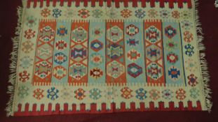 A flat weave Kilim rug with repeating geometric motifs, fringed 300x196cm