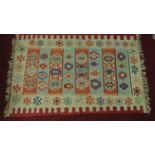 A flat weave Kilim rug with repeating geometric motifs, fringed 300x196cm