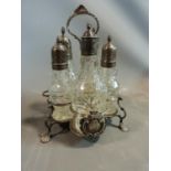 A Georgian silver and cut crystal cruet. White metal tops to the bottles. Shell design feet and
