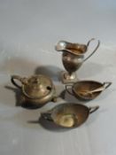 A collection of silver items including three silver salts, one with lions face feet, and a helmet