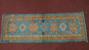 A Persian Heriz style runner, repeating stylised medallion throughout the field guarded by multi