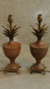 A pair of patinated metal pineapple shaped lamps on urn form bases with lion paw feet. H.41cm