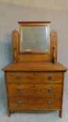 A late 19th century oak three drawer dressing chest with leaf carving and raised on bracket