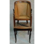 A Georgian mahogany child's bergere armchair on base with reeded swept supports. H.91cm