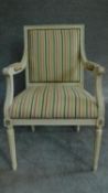 A Louis XVl style painted white armchair in striped upholstery and raised on tapering fluted