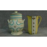 An antique hand painted jug with floral design and a ceramic lidded jar. With stamp to base. H.