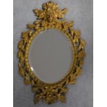 An oval bevelled wall mirror in gilt metal swag decorated frame. 45x30cm