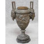 An antique bronze twin handled urn of classical form with cherub and satyr motifs. H.40cm