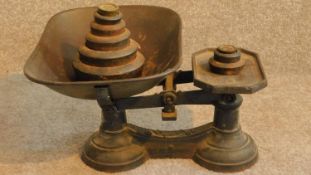 A vintage set of green painted iron grocers scales with its set of weights. 20x36cm