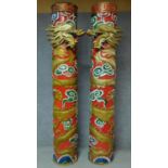 A pair of carved painted and gilded Chinese pillars with dragons wrapped around them and stylised