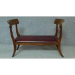 A 19th century mahogany window seat in red leather upholstery, raised on sabre supports. H.84 W.