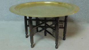 An Eastern decorative brass centre table with carved base. H.45 W.89 D.89cm