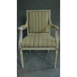 A Louis XVl style painted white armchair in striped upholstery and raised on tapering fluted