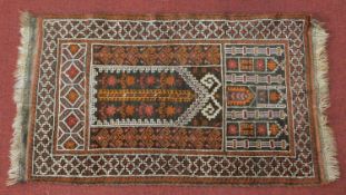 A prayer rug with repeating floral columns with geometric borders. 149x82cm