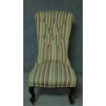 A Victorian mahogany nursing chair in candy striped buttoned back upholstery. H.103cm