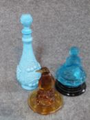 Two antique glass flower frog centre pieces, one in amber glass of a penguin, one frosted blue glass